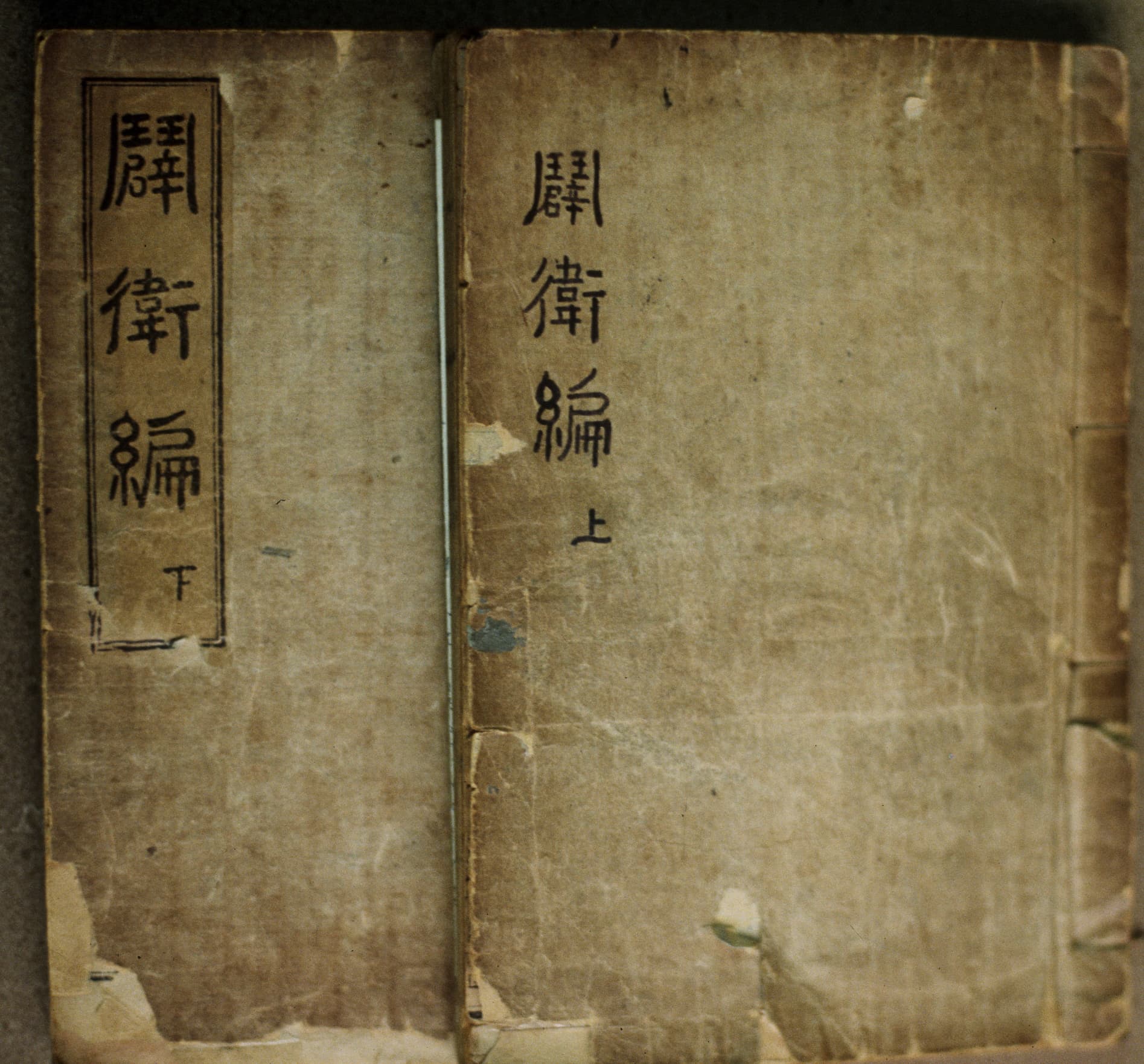 Two worn thread-bound volumes of Pyŏgwip’yŏn with the title written vertically on their covers.
